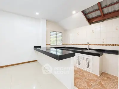 Modern kitchen with sleek countertops and tiled flooring in a bright, open space.