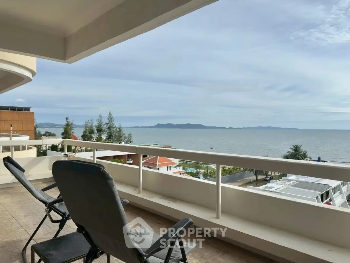 Stunning ocean view from spacious balcony with seating, perfect for relaxation.