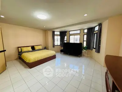 Spacious bedroom with large windows and modern furnishings