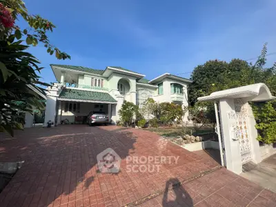 Stunning two-story house with spacious driveway and lush garden in serene neighborhood.