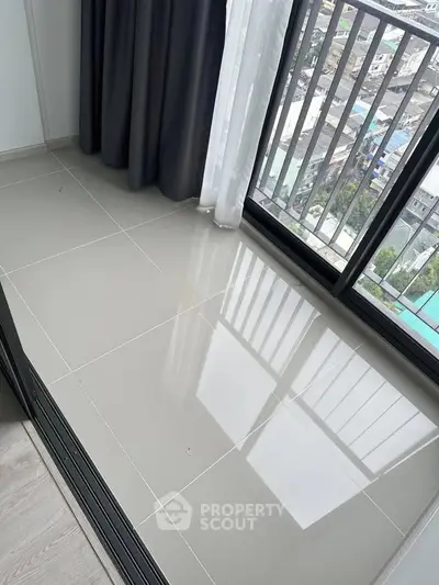 Modern apartment balcony with city view and sleek tiled flooring.