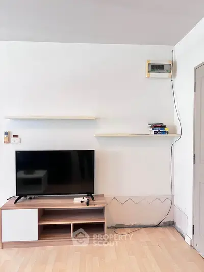 Modern living room with minimalist TV stand and wall-mounted shelves