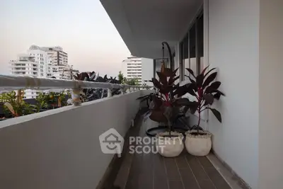 Spacious balcony with potted plants and city view in modern apartment