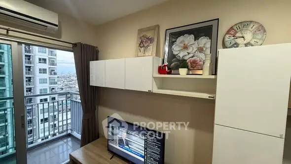 Modern living room with balcony view in high-rise apartment, featuring stylish decor and wall-mounted TV.
