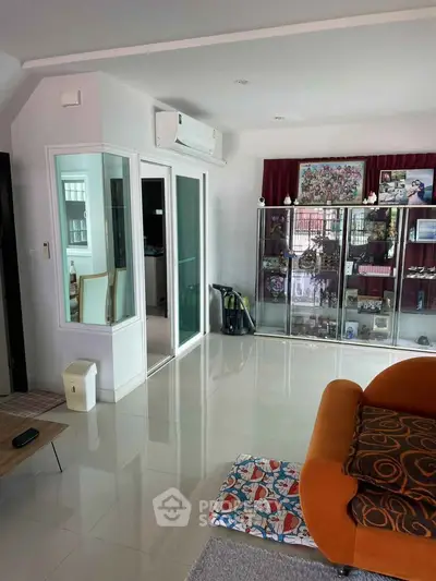 Spacious living room with modern decor and glass display cabinets
