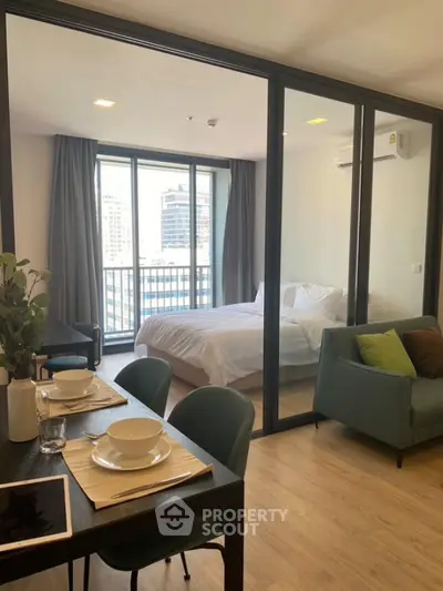 Modern open-plan living room with glass partition and city view balcony