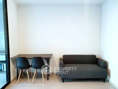 Modern minimalist living room with sleek black sofa and dining set, perfect for urban living.