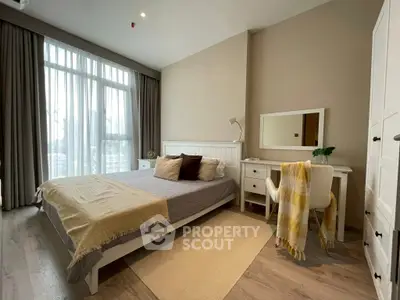 Spacious bedroom with modern decor and large window for natural light