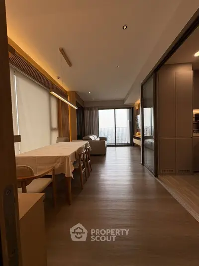 Modern living room with dining area and balcony view in a stylish apartment.