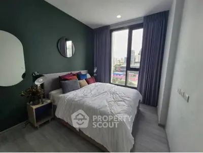 Modern bedroom with city view, featuring stylish decor and large window for natural light.