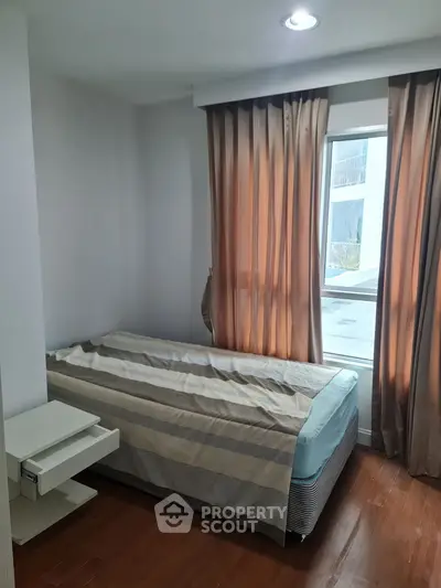 Cozy bedroom with single bed and window view, perfect for a peaceful retreat.