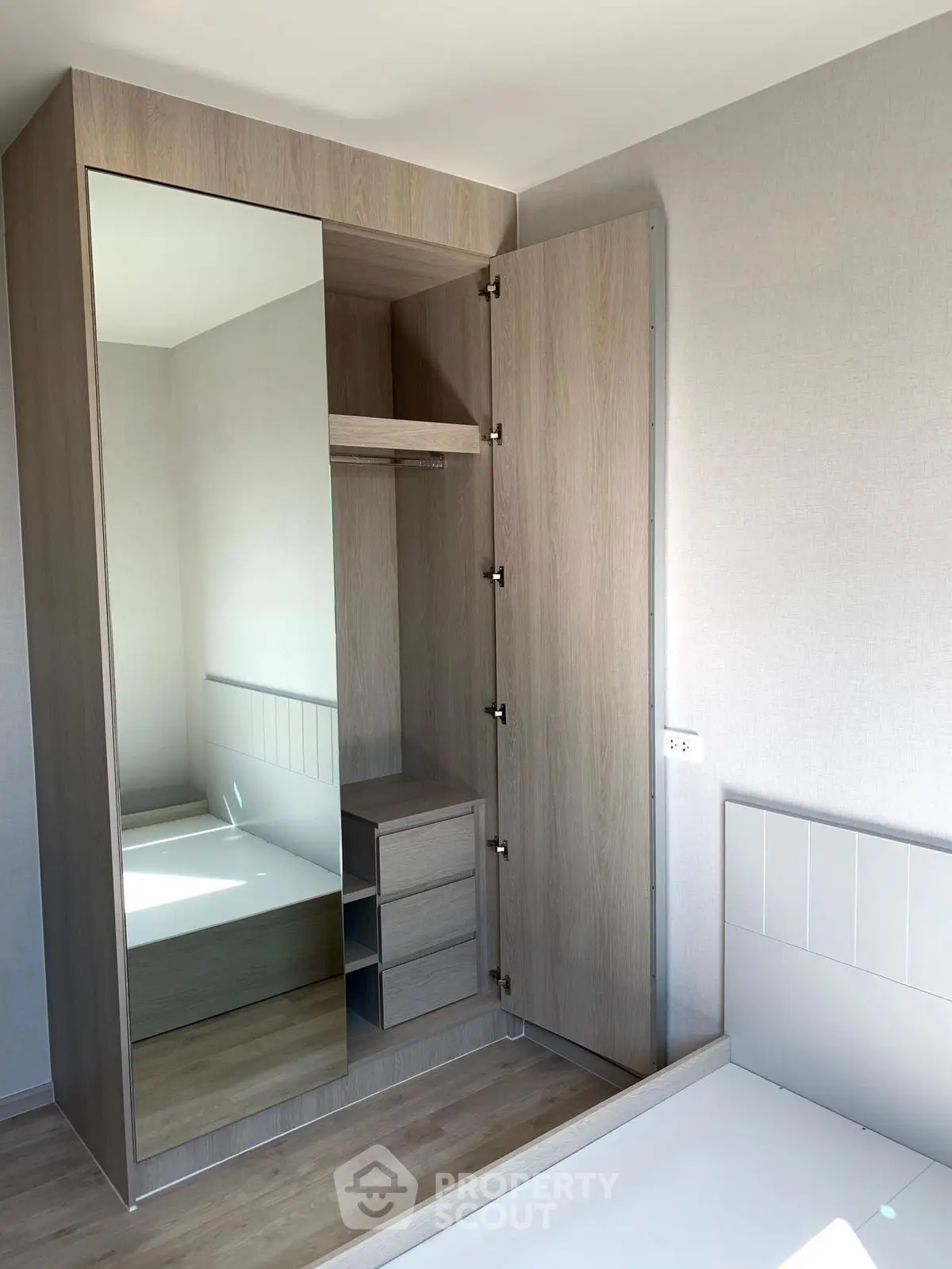 Modern bedroom with built-in wardrobe and mirrored door