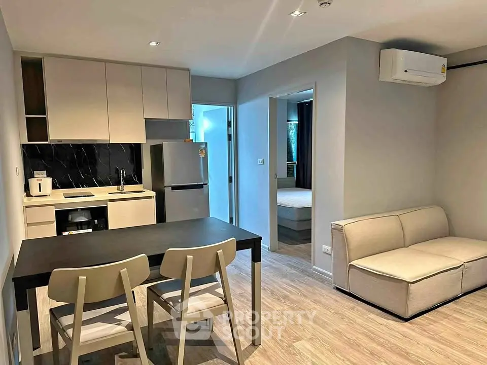 Modern open-plan kitchen and living area with sleek furniture and appliances