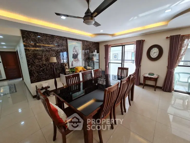 Elegant dining room with modern ceiling fan and large windows for natural light.