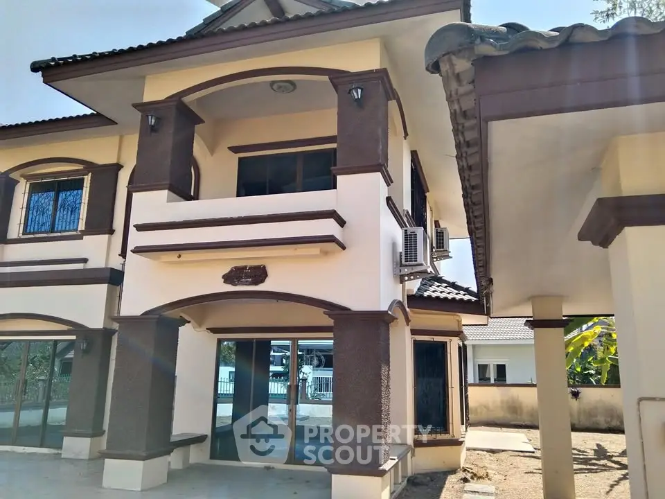 Charming two-story house with unique architectural details and spacious balcony.