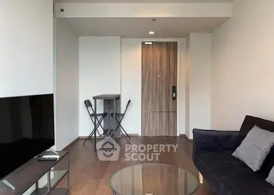 Modern living room with sleek furniture and wooden flooring, featuring a cozy seating area and stylish decor.