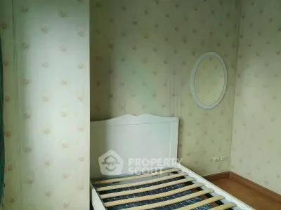 Charming bedroom with floral wallpaper and bed frame, perfect for cozy living.