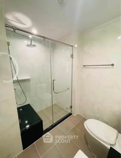 Modern bathroom with glass shower enclosure and sleek fixtures in a contemporary home.