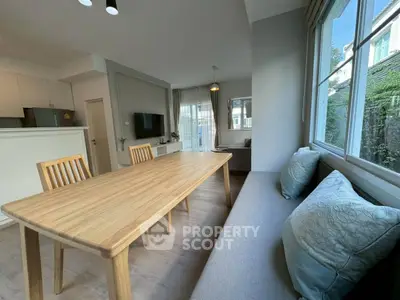 Spacious modern living room with dining area and large windows offering natural light.