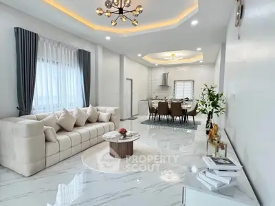 Luxurious open-plan living room with elegant decor and modern kitchen.