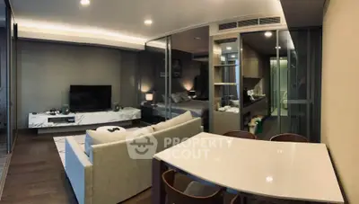 Modern open-plan living room with sleek furniture and glass partitions