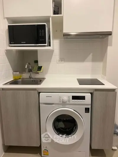 Compact kitchen with washing machine, microwave, and electric stove