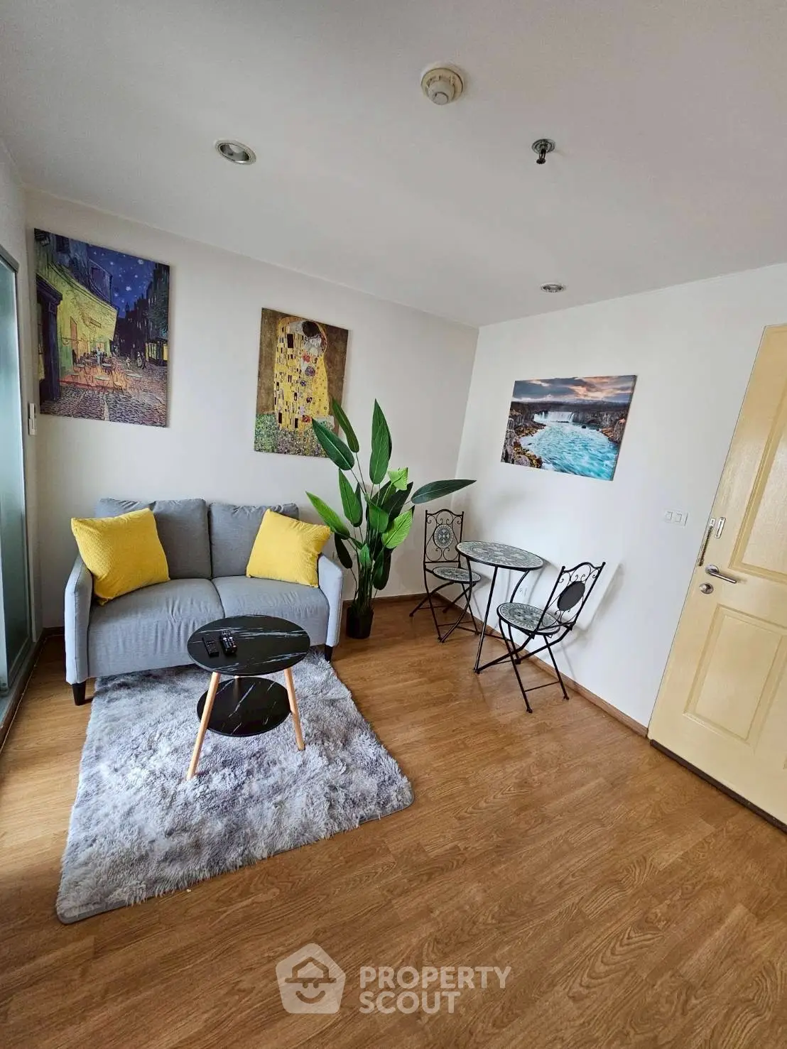 Charming living room with cozy sofa, stylish decor, and elegant wooden flooring.