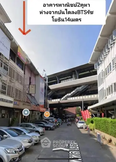 Commercial building exterior near BTS station with parking area and street view.