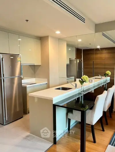 Modern kitchen with sleek design, featuring stainless steel appliances and elegant dining area.