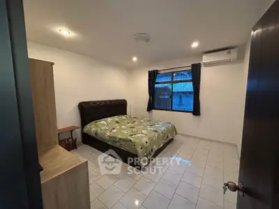 Cozy bedroom with tiled floor, double bed, and air conditioning unit.