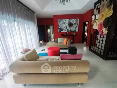 Stylish living room with modern decor and unique art pieces, featuring cozy sofas and vibrant accents.