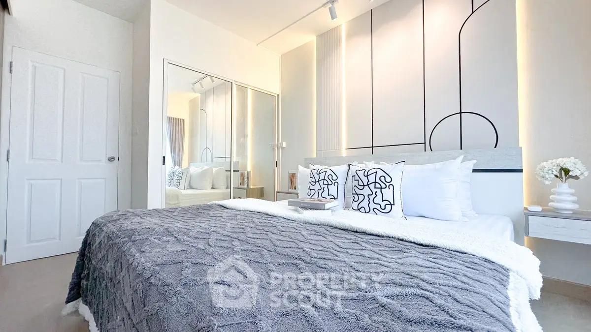 Modern bedroom with stylish decor and mirrored closet doors