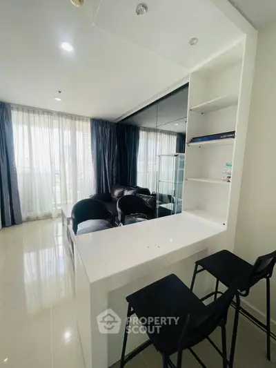 Modern living room with sleek furniture and large windows offering natural light.