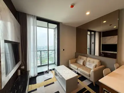 Modern living room with city view, featuring sleek furniture and large windows for natural light.