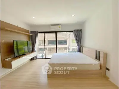 Modern bedroom with large window and stylish wooden furniture