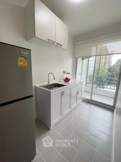 Modern kitchen with sleek cabinetry and balcony view