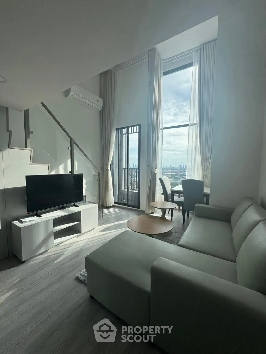 Modern living room with high ceilings and city view balcony