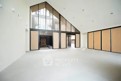 Spacious modern living room with high ceilings and large windows in a contemporary home.