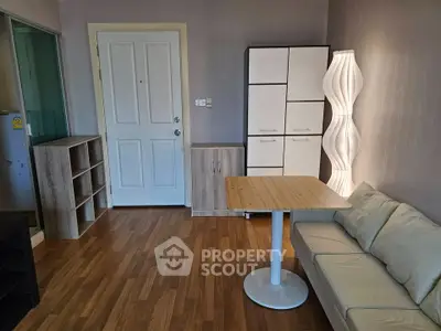 Modern living room with stylish furniture and wooden flooring, featuring a cozy sofa and elegant lighting.