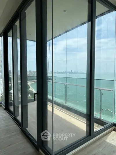 Stunning ocean view from modern high-rise balcony with glass doors