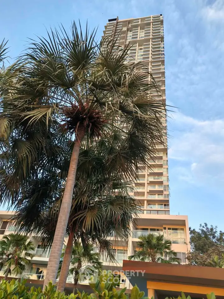 Stunning high-rise building with lush palm trees and clear blue sky