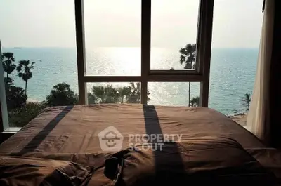 Stunning bedroom with breathtaking ocean view through large windows, perfect for relaxation.
