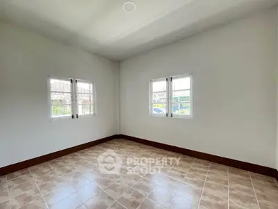 Spacious empty room with tiled floor and large windows, perfect for customization.