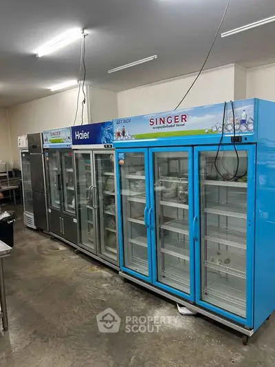 Spacious commercial kitchen with multiple refrigerators and ample storage space.