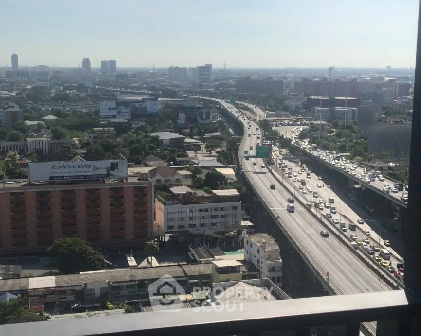 Stunning cityscape view from high-rise balcony overlooking busy highway and urban skyline.