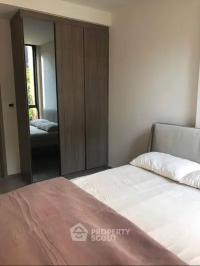 Cozy bedroom with modern wardrobe and natural light, perfect for relaxation.