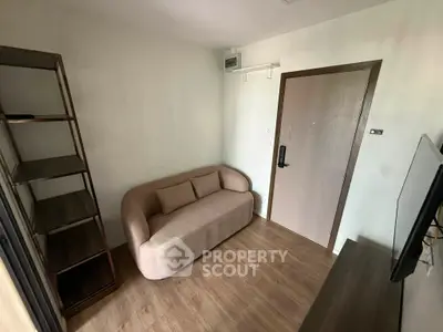 Cozy living room with modern sofa and wooden flooring, perfect for relaxation.