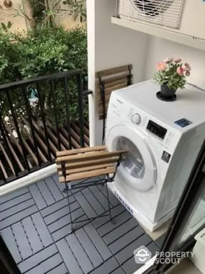 Charming balcony with washing machine and seating area, perfect for urban living.