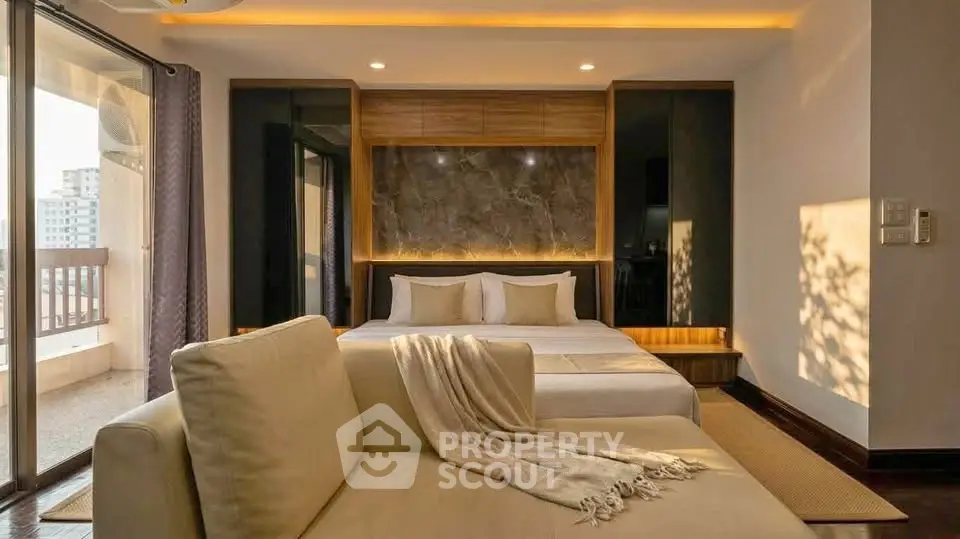 Luxurious bedroom with modern decor and balcony view in upscale apartment