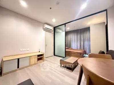 Modern apartment interior with open living room and bedroom, featuring sleek furniture and ambient lighting.
